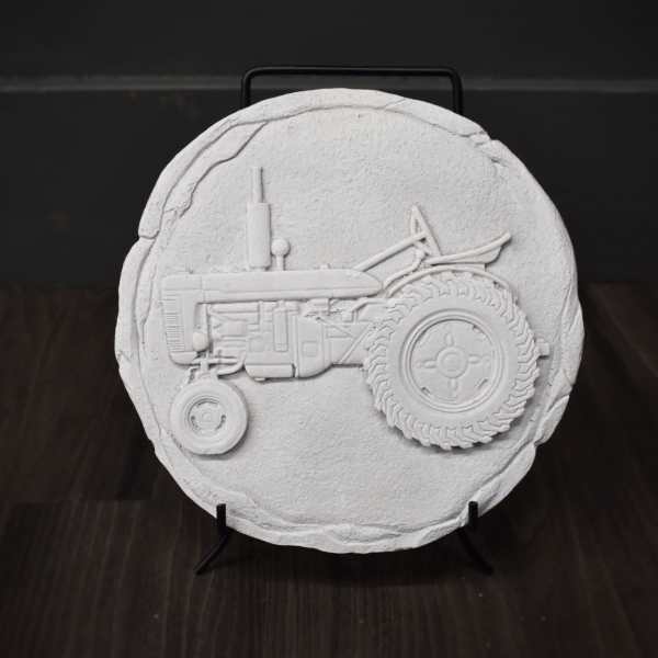 Round white decorative plaque with a raised tractor design