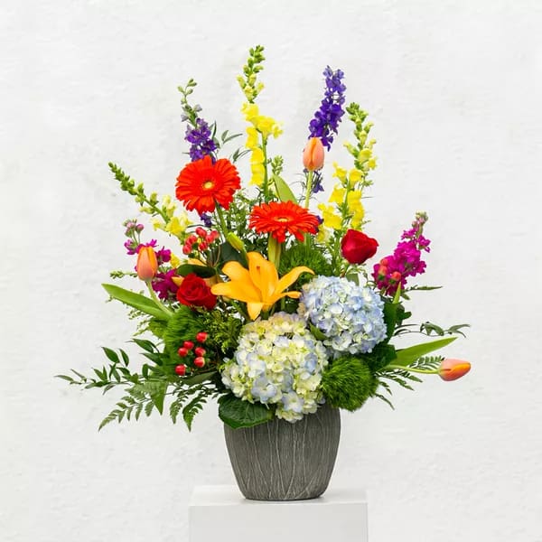 Colorful mixed flower arrangement in a gray vase