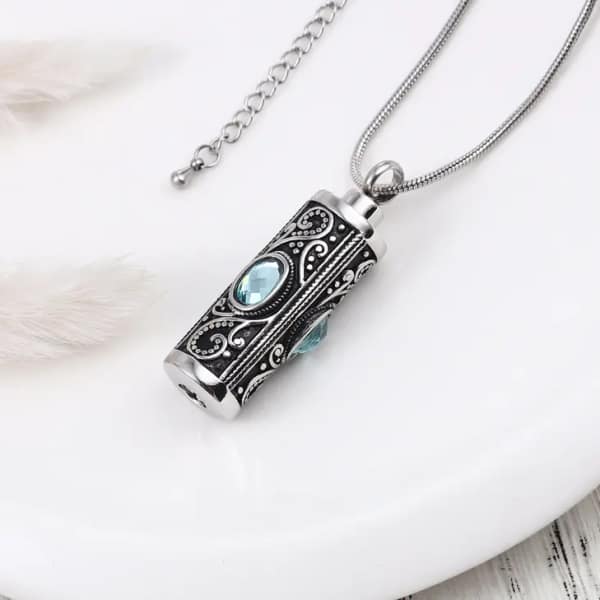 Silver pendant necklace with blue stones on a white surface