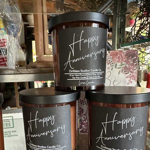 Three anniversary candles in dark glass jars with black lids