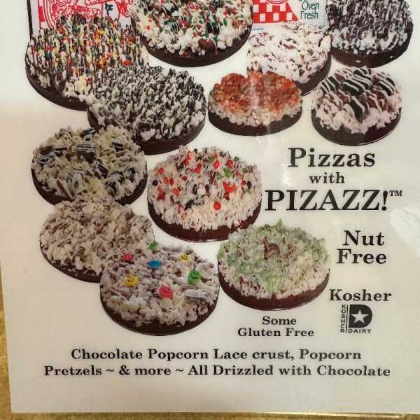 Poster showing assorted chocolate-drizzled popcorn pizzas in pizza boxes