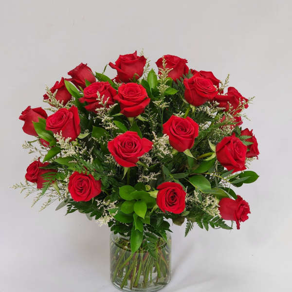 Red roses arranged in a clear glass vase