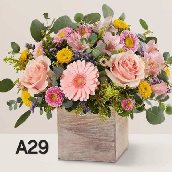 Pink and yellow mixed flower arrangement in a wooden box