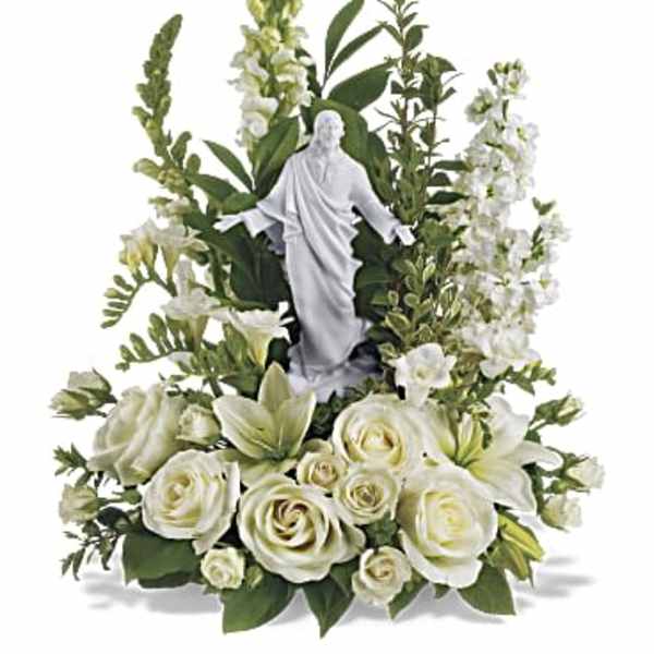 White floral arrangement with a religious statue centerpiece