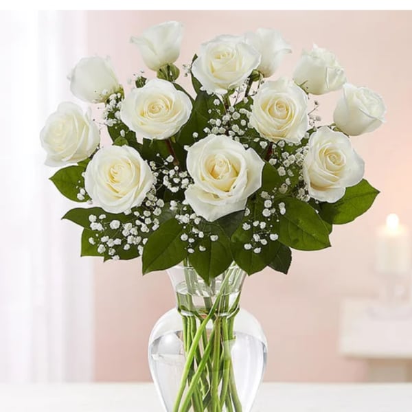 White roses arranged in a clear glass vase