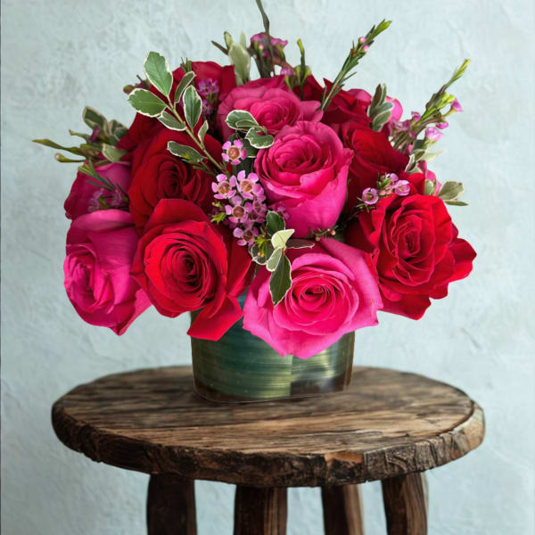 Mixed bouquet of white, pink, orange, and magenta flowers in a green vase
