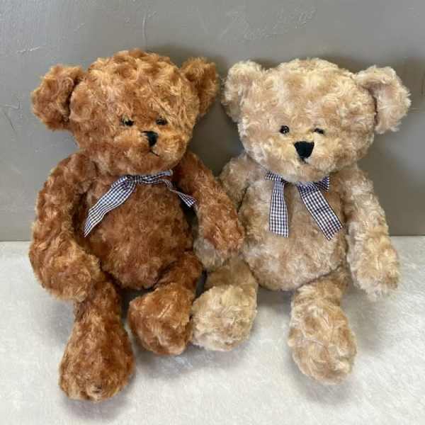 Two plush teddy bears with gingham bows sitting side by side