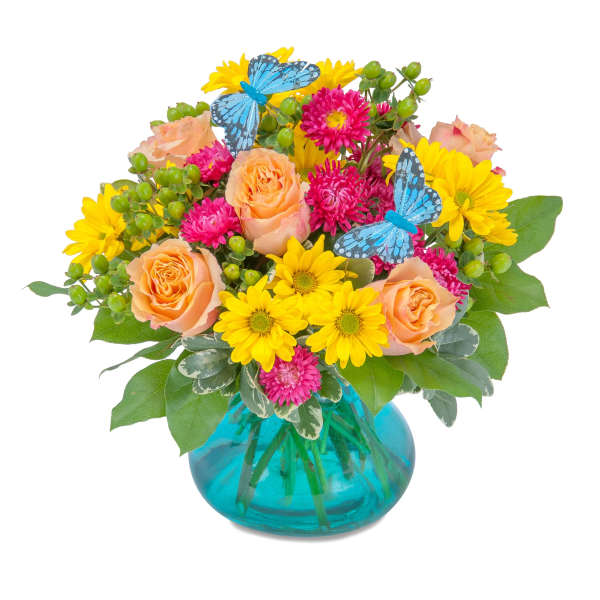 Peach roses and yellow daisies in a blue glass vase with butterfly picks
