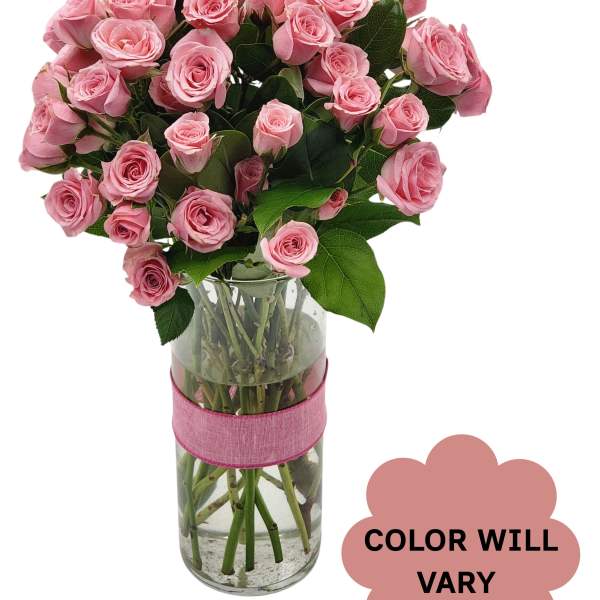 Bouquet of pink roses in a clear glass vase with a pink ribbon