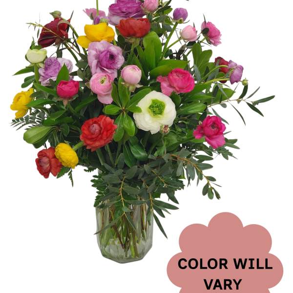 Mixed bouquet of colorful ranunculus in a glass vase