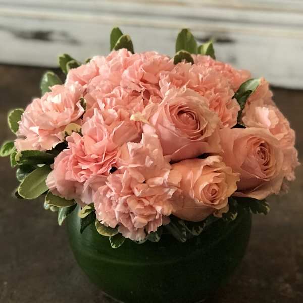 Pink roses and carnations arranged in a green vase