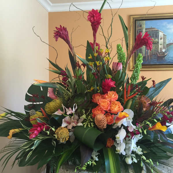 Large tropical flower arrangement with orange roses and orchids