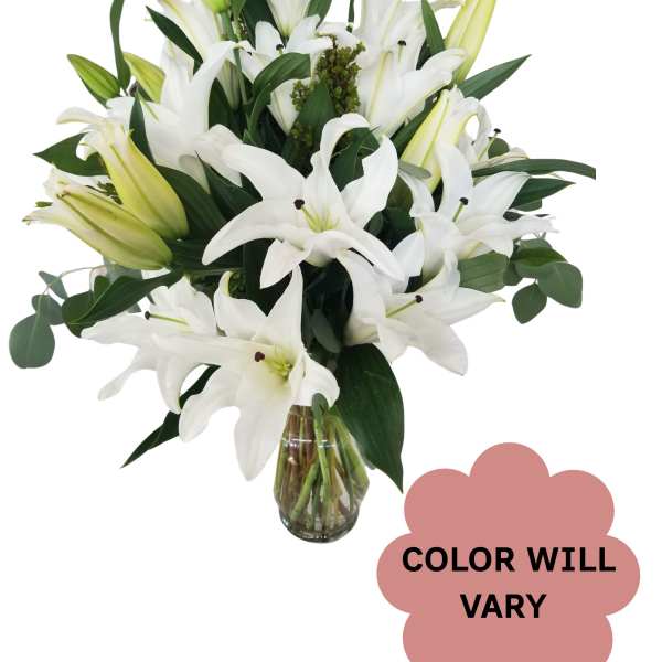 White lilies arranged in a clear glass vase