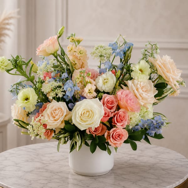 Pastel mixed flower arrangement in a white vase