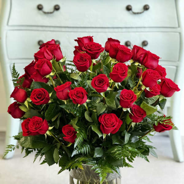 Red roses arranged in a clear glass vase