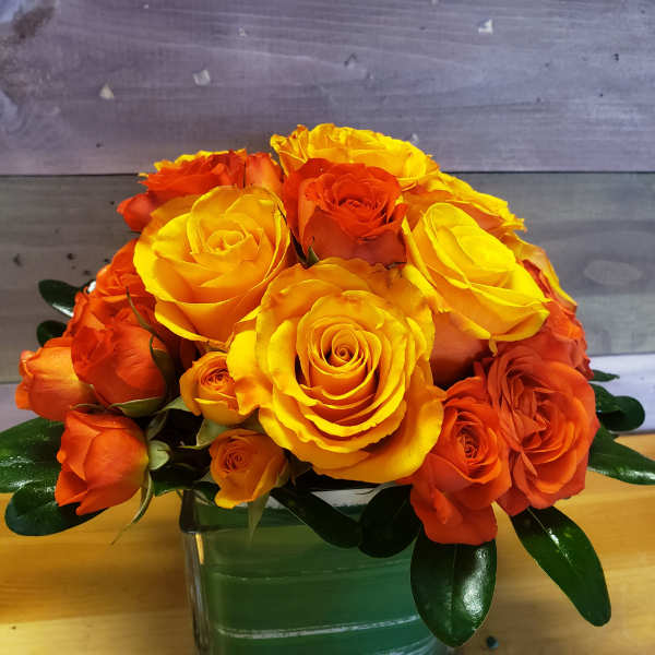 Bouquet of yellow and orange roses in a glass vase