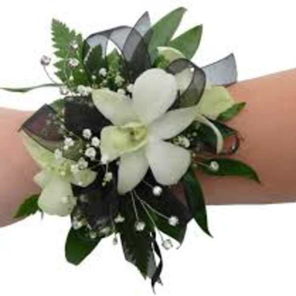 White floral wrist corsage with ribbon and greenery