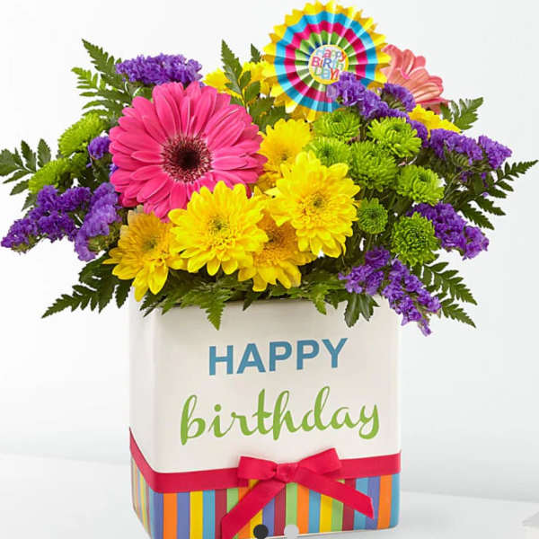 Birthday flower arrangement in a striped gift box with a ribbon