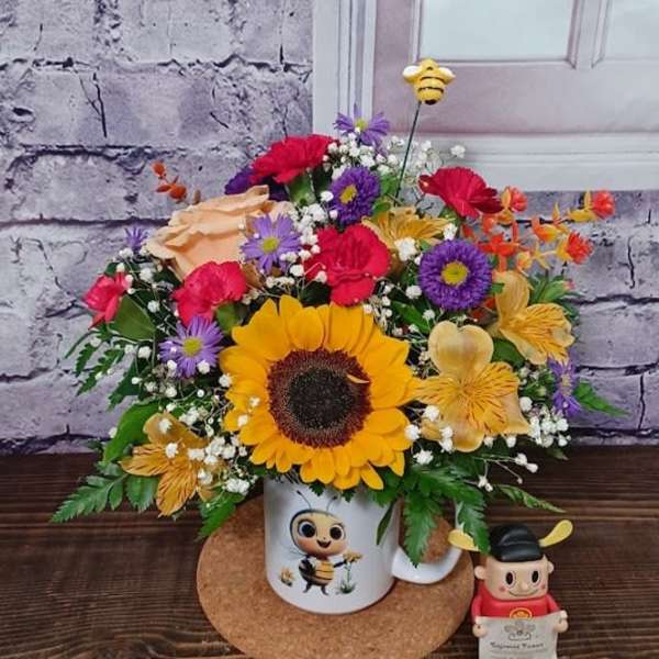 Sunflower bouquet in a mug with a small bee figurine