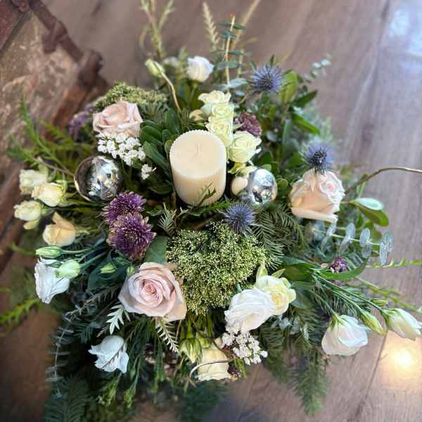 Floral centerpiece with roses, lisianthus, and a candle