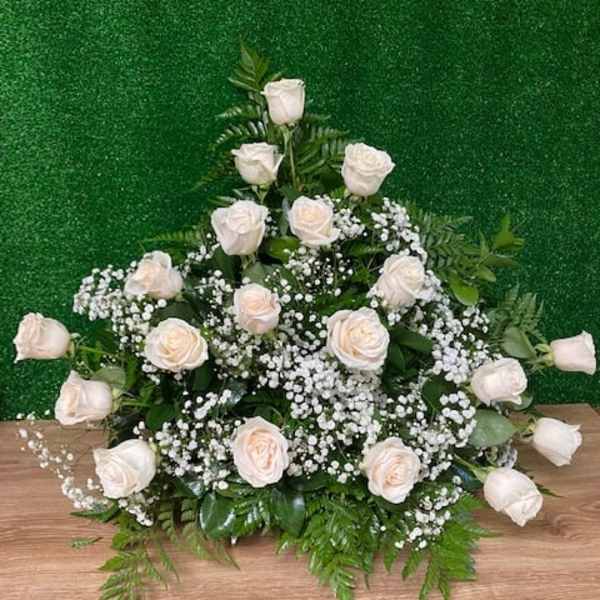 White rose arrangement with baby's breath on a green backdrop