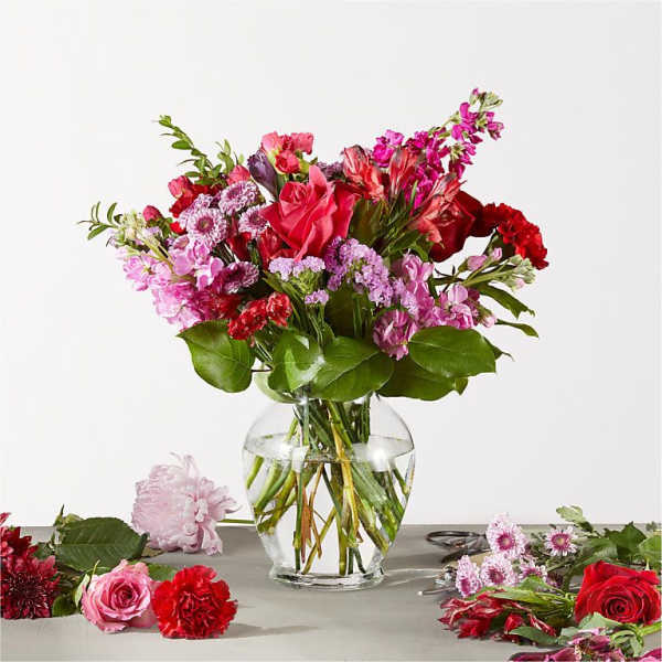 Mixed pink and red flower bouquet in a clear glass vase