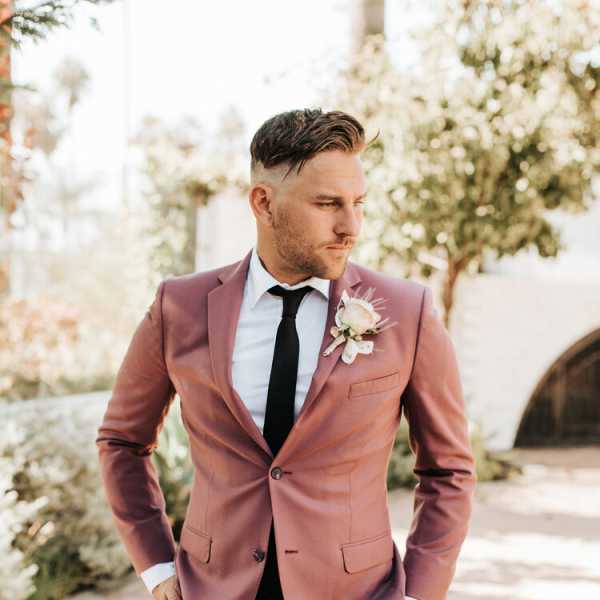 Man in a mauve suit wearing a boutonniere