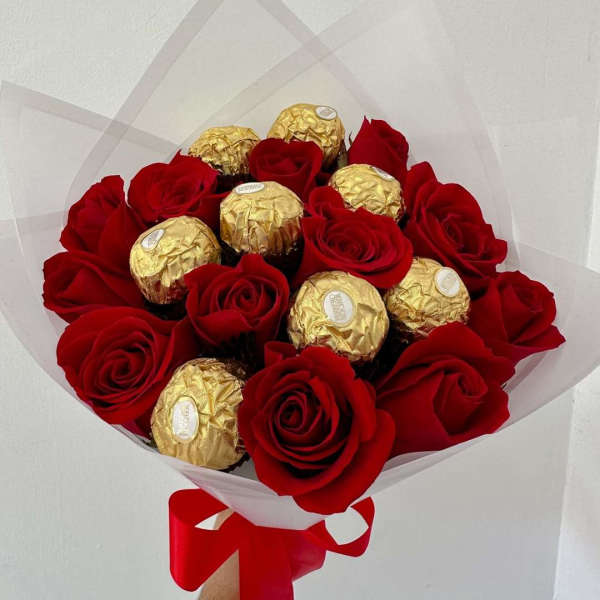 Bouquet of red roses and gold-wrapped chocolates with a red ribbon