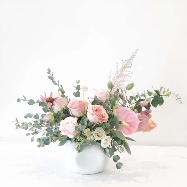 Pink and white floral arrangement in a white vase