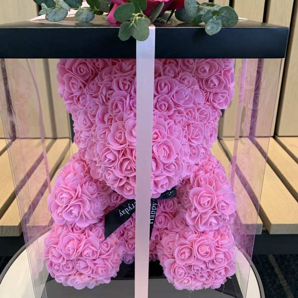 Pink rose teddy bear in a clear gift box with a ribbon