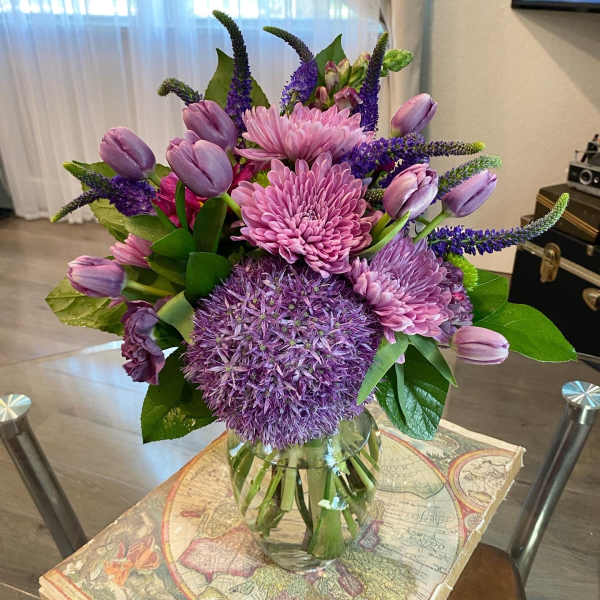 Purple and pink mixed bouquet in a clear glass vase