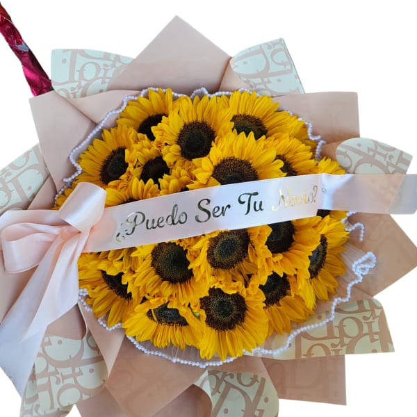 Bouquet of yellow sunflowers wrapped in pink paper with a ribbon
