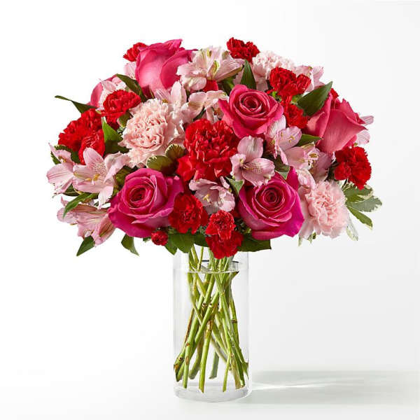 Pink and red mixed flower bouquet in a clear glass vase