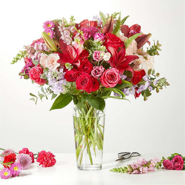 Mixed pink and red flower bouquet in a clear glass vase