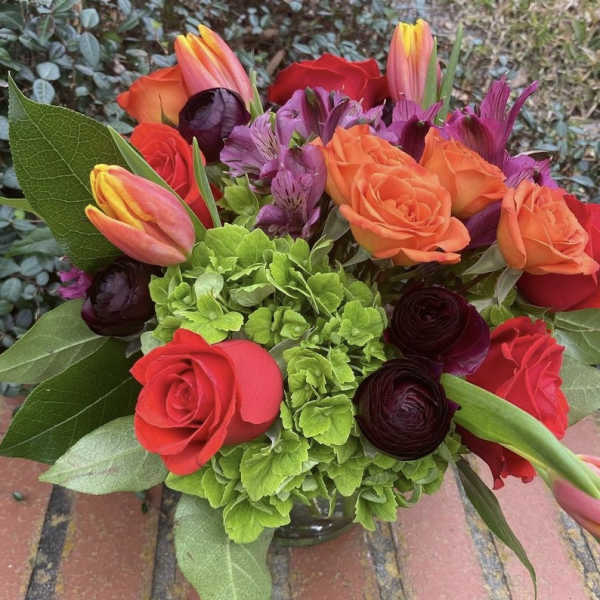 Bouquet of orange and red roses with tulips and purple flowers
