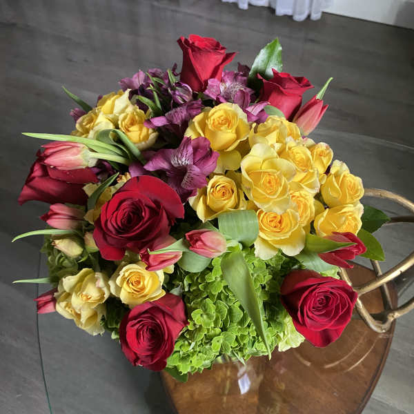 Bouquet of red and yellow roses with pink tulips and purple flowers