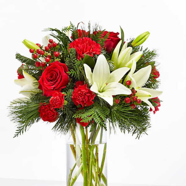 Red roses, white lilies, and carnations in a clear glass vase