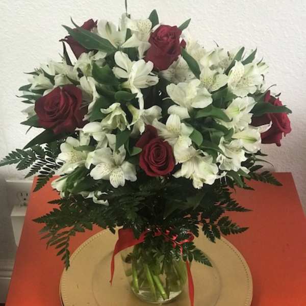 Bouquet of red roses and white alstroemeria in a glass vase
