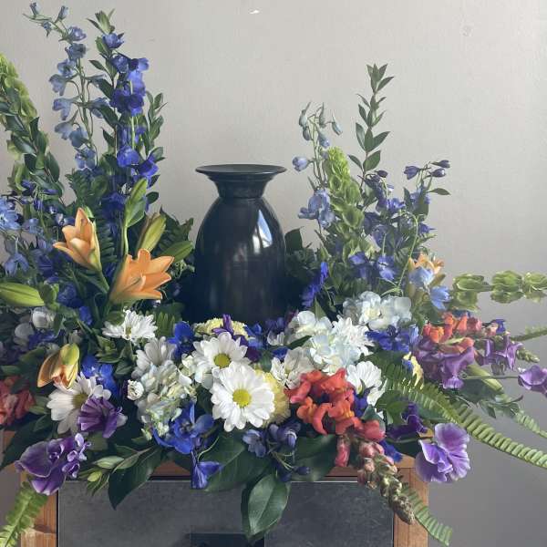 Colorful floral arrangement with a dark vase centerpiece and mixed blooms