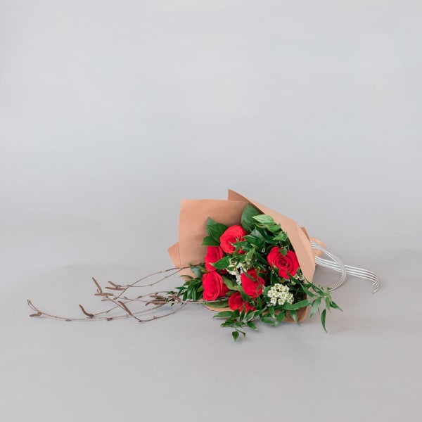 Bouquet of red roses wrapped in tan paper