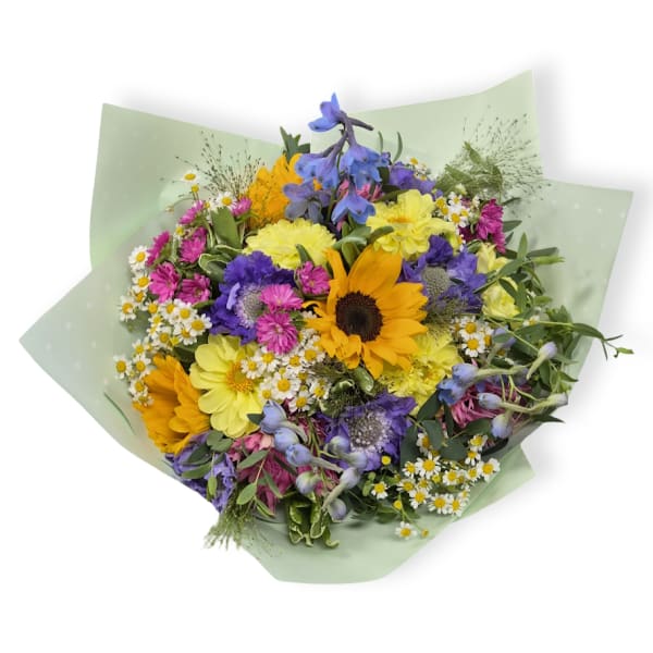 Mixed bouquet with sunflowers, daisies, and purple blooms in pale green wrap