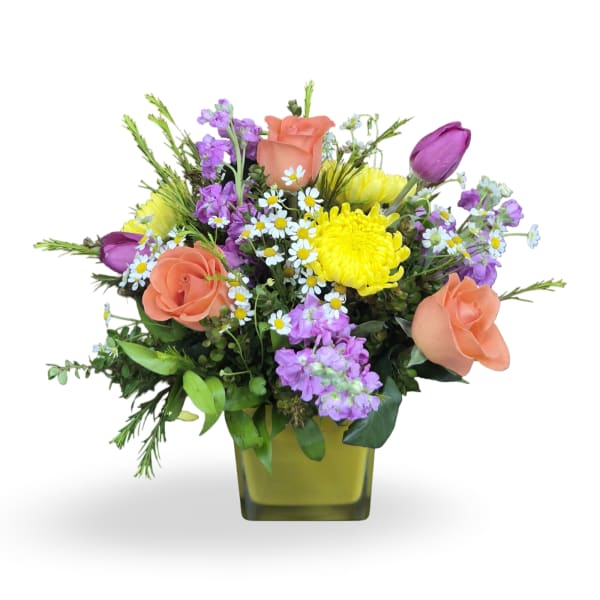 Mixed bouquet of peach roses, purple tulips, and yellow chrysanthemums in a square vase