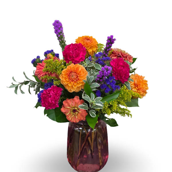 Colorful mixed flower arrangement in a purple glass vase