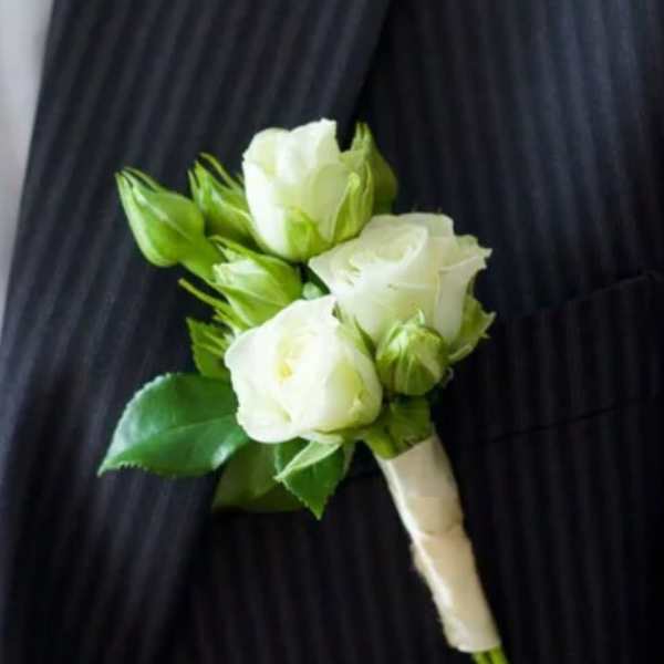White rose boutonniere with green buds and leaves