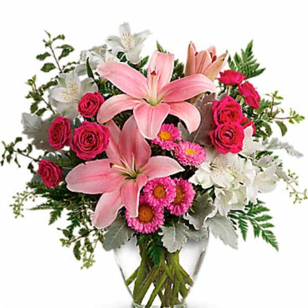 Pink lilies and roses in a clear glass vase with white flowers