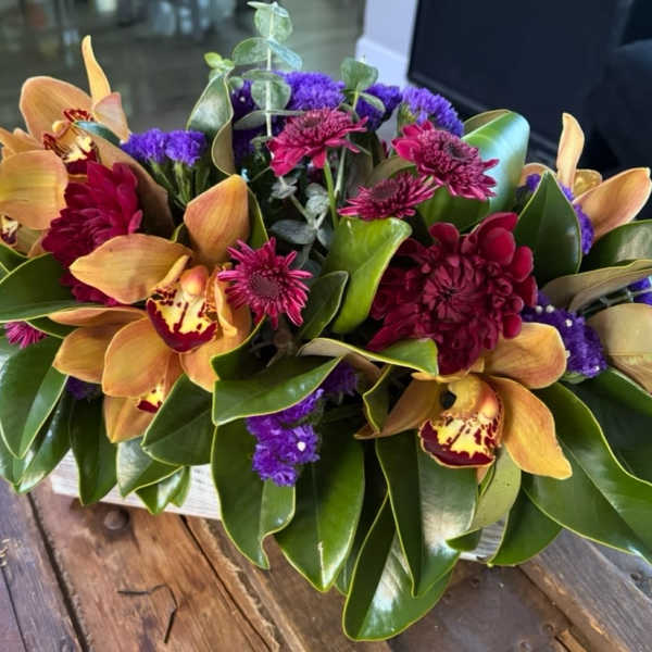 Tropical bouquet with orange orchids and magenta flowers