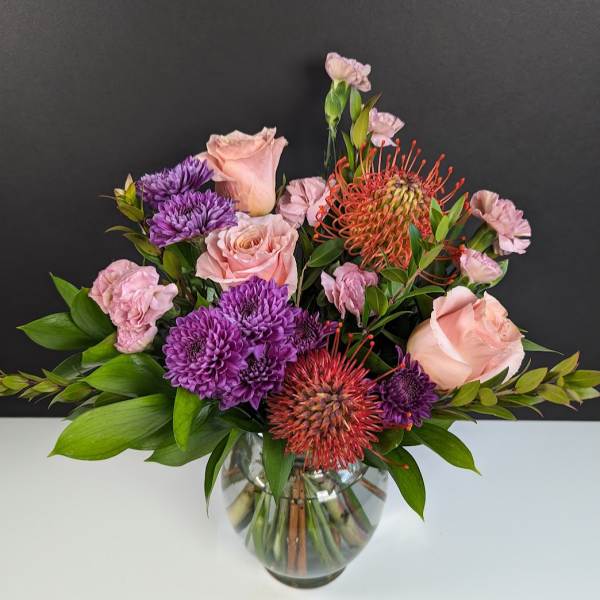 Pink and purple mixed bouquet in a glass vase
