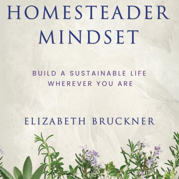 Book cover with the title The Homesteader Mindset and herbs at the bottom
