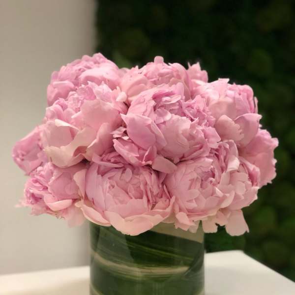 Pink peonies arranged in a green glass vase