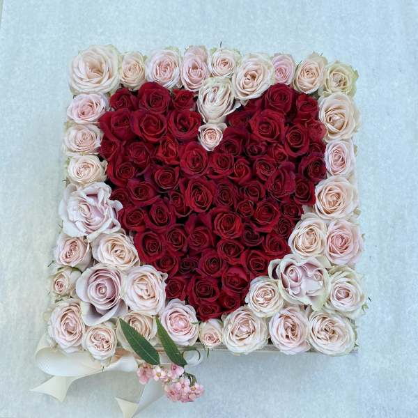 Heart-shaped rose arrangement in red and blush pink